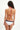 Woman wearing a white bikini with red and black accents on a white background