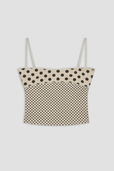 Polka dot top with thin straps on a light gray background