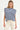 Woman wearing a blue and grey striped top and white pants on a white background