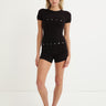 black shortsleeve knit romper with mother of pearl buttons at bust and waist
