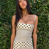 Woman wearing a polka dot top against a green leafy background