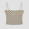 Polka dot top with thin straps on a light gray background